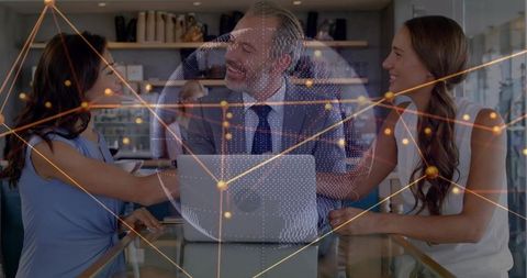 Executives Collaborating Around Laptop with Digital Globe and Network Overlay