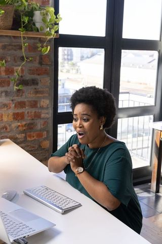 Surprised Woman Reacting to Laptop in Modern Home Office