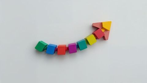 Colorful upward curved arrow with wooden blocks symbolizing growth