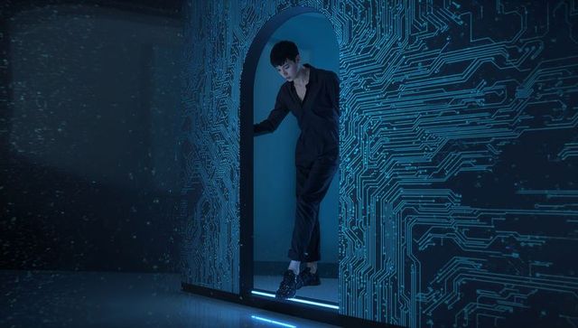 Male model standing in neon tech arch with circuit wall, cyan lighting, futuristic vibe