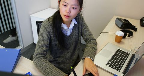 Focused Businesswoman Using Laptop and Tablet in Office