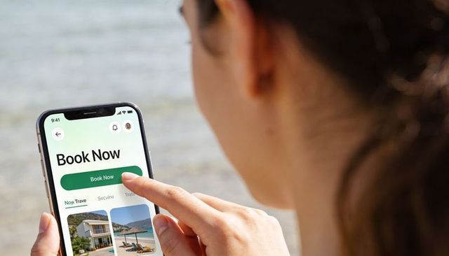 Woman tapping book now on travel app at beach smartphone booking and vacation planning