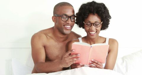 Couple bonding through shared reading experience in bed