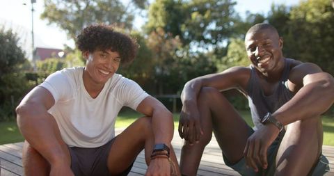 Smiling Diverse Friends Relaxing in Sunlit Backyard After Workout