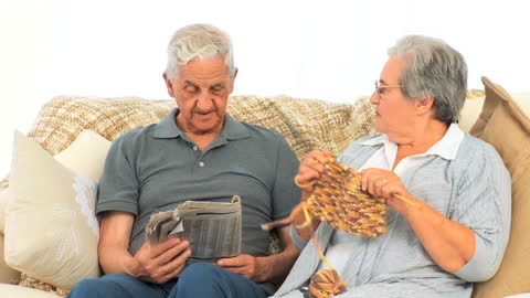 Senior Couple Enjoying Quiet Time with Knitting and Reading