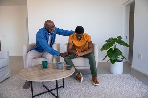 Father Consoling Son in Modern Living Room During Emotional Moment