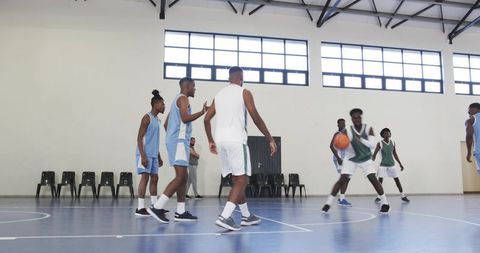 Diverse Male Group Competing on Basketball Court Indoors