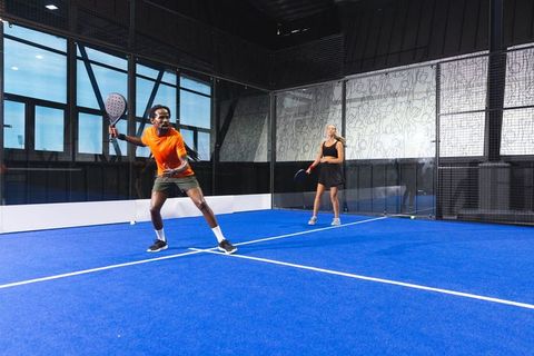 Diverse athletes playing competitive padel on modern court