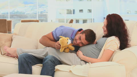 Expectant Couple Enjoying Leisure Time with Teddy Bear
