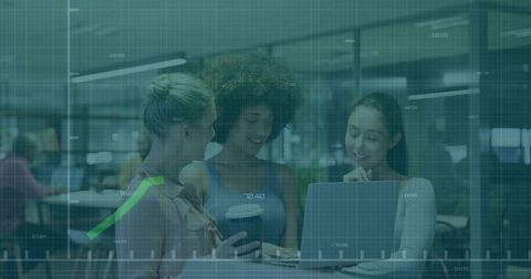 Women collaborating on data visualization with laptop and coffee in modern coworking hub