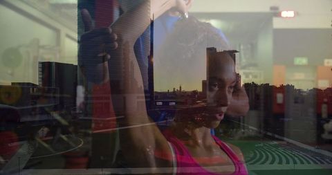 Athlete Stretching with Coach in Gym Overlooking Urban Skyline