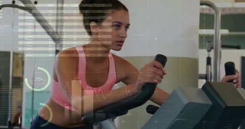 Woman Analyzing Fitness Data on Stationary Bike in Gym