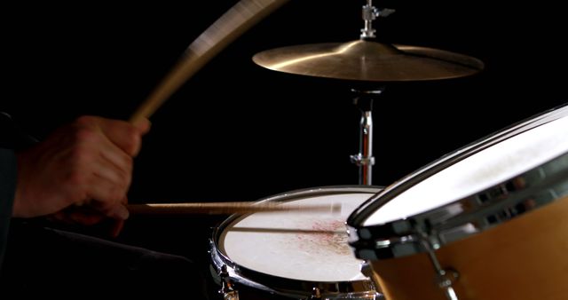 Drummer playing his drum kit on black background - Download Free Stock Photos Pikwizard.com