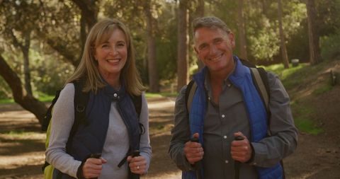Joyful Senior Couple Hiking in Sunny Forest with Walking Equipment - Download Free Stock Images Pikwizard.com