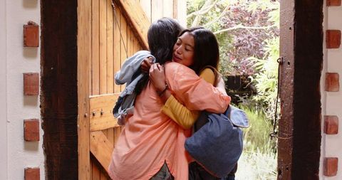 Heartfelt Mother and Daughter Embrace by Garden Doorway