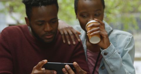 Young African American Couple Engaging with Smartphone Together