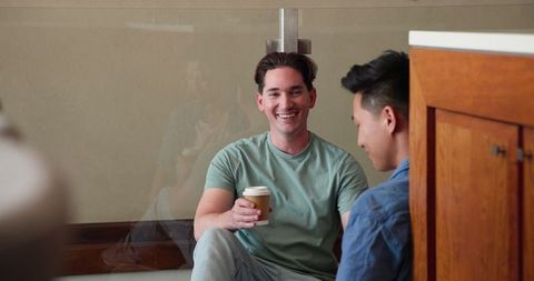 Happy Diverse Male Couple Chatting Over Coffee at Home