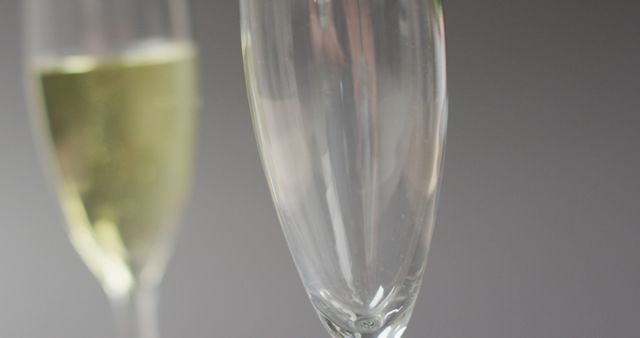 Image of champagne pouring into glass on grey background. alcohol, beverage, drinks, party and celebration concept.