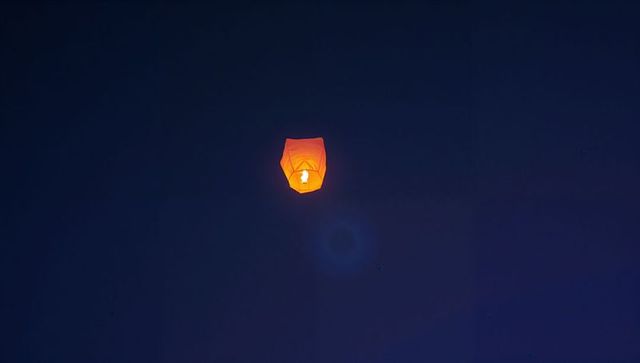 Glowing sky lantern brightening tranquil night sky