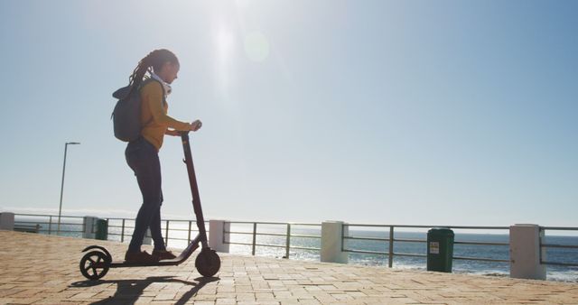 Young Woman Riding Electric Scooter on Sunny Coastal Path - Download Free Stock Images Pikwizard.com