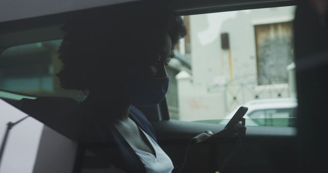 Masked Woman Sitting Inside Car Using Smartphone, Urban Background - Download Free Stock Images Pikwizard.com