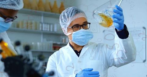 Scientist examining liquid in laboratory with superimposed chemical formulas