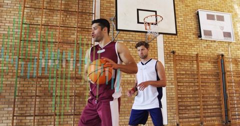 Young Basketball Player Driving to Hoop in School Gym While Teammate Defends