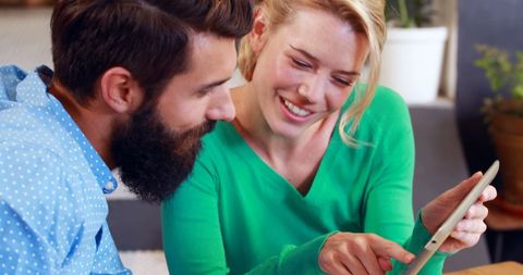 Couple Enjoying Tablet Together in Cozy Cafe Setting
