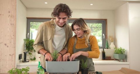 Couple Enjoying Indoor Gardening in Modern Kitchen