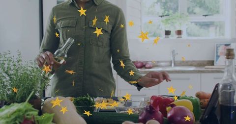 Pouring olive oil while dressing chopped peppers and onions on bright kitchen counter
