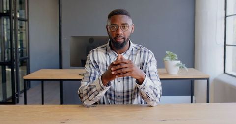 Businessman in Plaid Shirt Engaging in Conversation at Modern Office Desk - Download Free Stock Images Pikwizard.com
