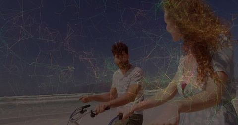 Couple Riding Bicycles along Beachside Shoreline