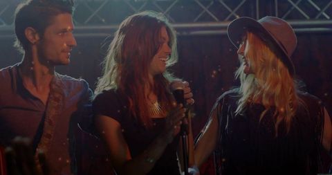 Energetic bandmates performing on stage with crowd interaction