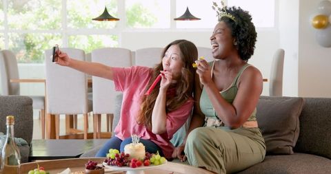 Joyful Lesbian Couple Celebrating Birthday with Food and Selfie