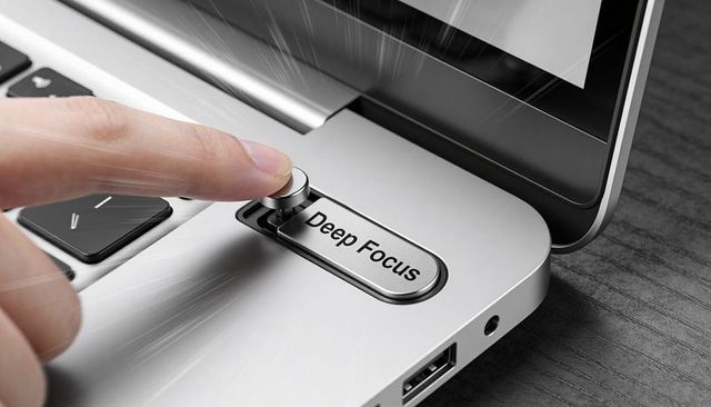 Pressing deep focus dial on laptop palmrest for productivity and concentration