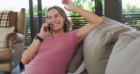 Happy Pregnant Woman Enjoying Relaxing Phone Call on Sofa