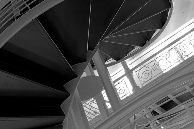 Elegant spiral staircase in black and white. Ideal for use in architectural designs, home decor magazines, interior design portfolios and presentations, and artistic projects requiring intricate structural elements.