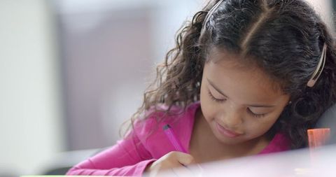 Young Biracial Girl Concentrating on Classroom Writing Task - Download Free Stock Images Pikwizard.com