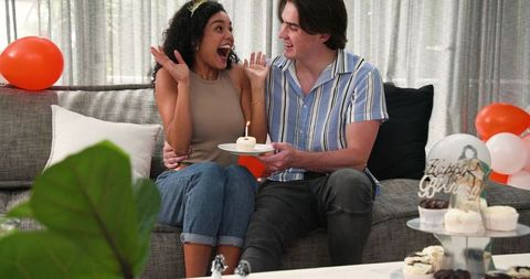 Happy multiracial couple celebrating birthday at home
