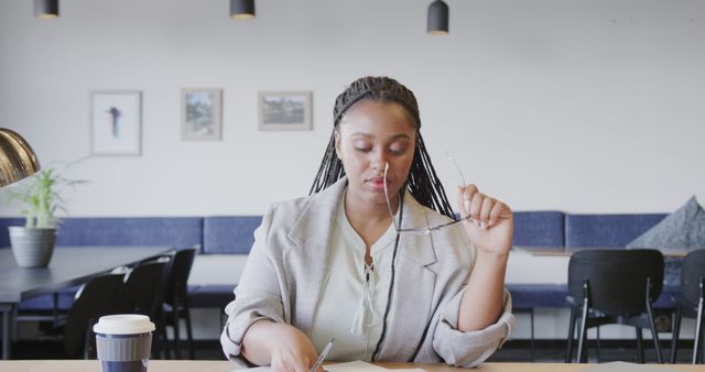 Focused African American Woman Writing in Modern Office Setting - Download Free Stock Images Pikwizard.com