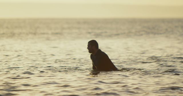 Solitary Man Wading in Calm Ocean Waters at Sunset - Download Free Stock Images Pikwizard.com