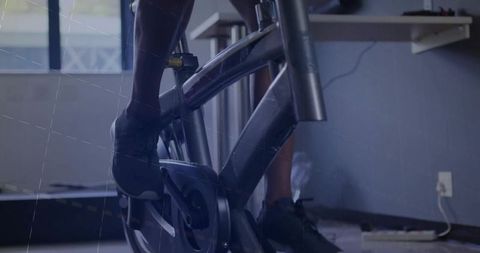 Focused Man Pedaling Stationary Bike for Fitness Workout