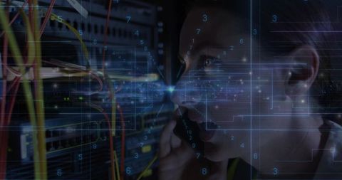 Technician holding handset connecting colorful network cables in server rack data overlay