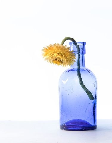 Minimalist Blue Glass Bottle with Yellow Flower Accent