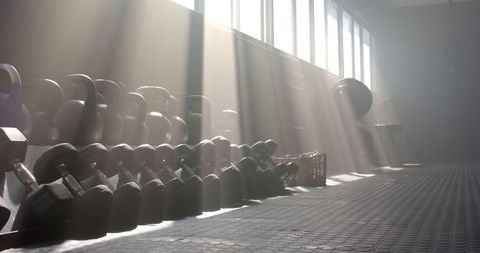 Sunlight Illuminating Kettlebells and Dumbbells in Modern Gym