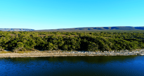 transparent tranquil hills facing blue water under clear sky - Download Free Stock Videos Pikwizard.com