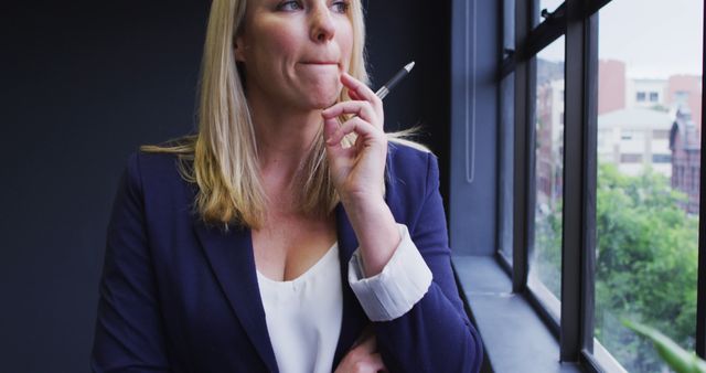 Contemplative Businesswoman Thinking by Window in Office - Download Free Stock Images Pikwizard.com