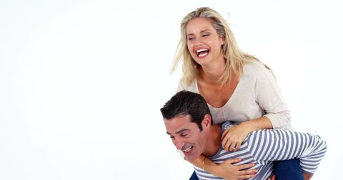 Cheerful couple piggyback bonding light celebration