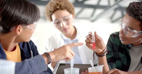 Teenagers conducting chemistry experiment in science class