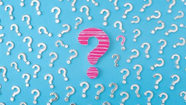 Question Mark Cutouts on Blue Background Highlight One in Pink